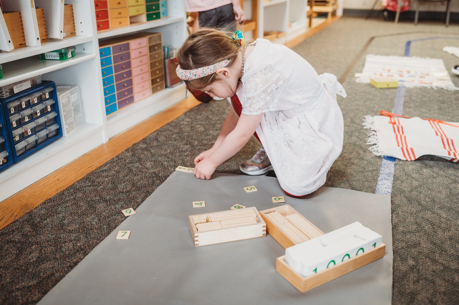 Girl deeply focused on Montessori number work developing math skills and concentration