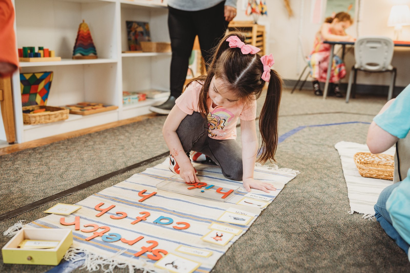 Child practicing letter formation with Montessori moveable alphabet at W Montessori Academy in Elmhurst IL